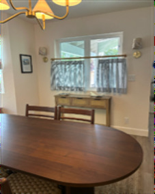 Dining room with oval table, brass sconces, and chandelier