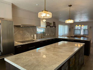 Open kitchen with range, refrigerator, island, and dining beyond